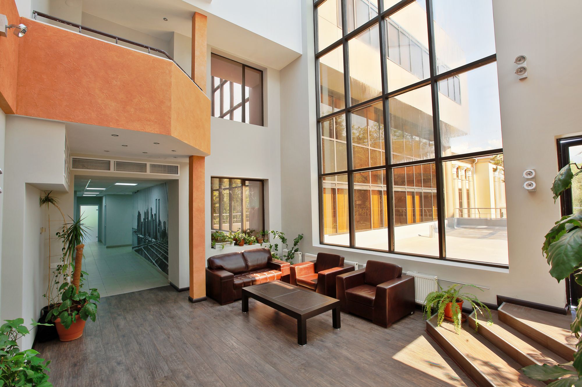A spacious, modern lobby with high ceilings, large windows, and contemporary furniture
