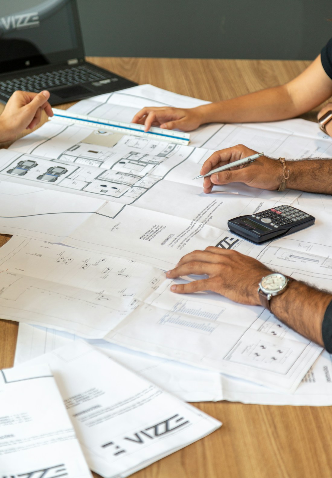 People reviewing architectural blueprints on desk
