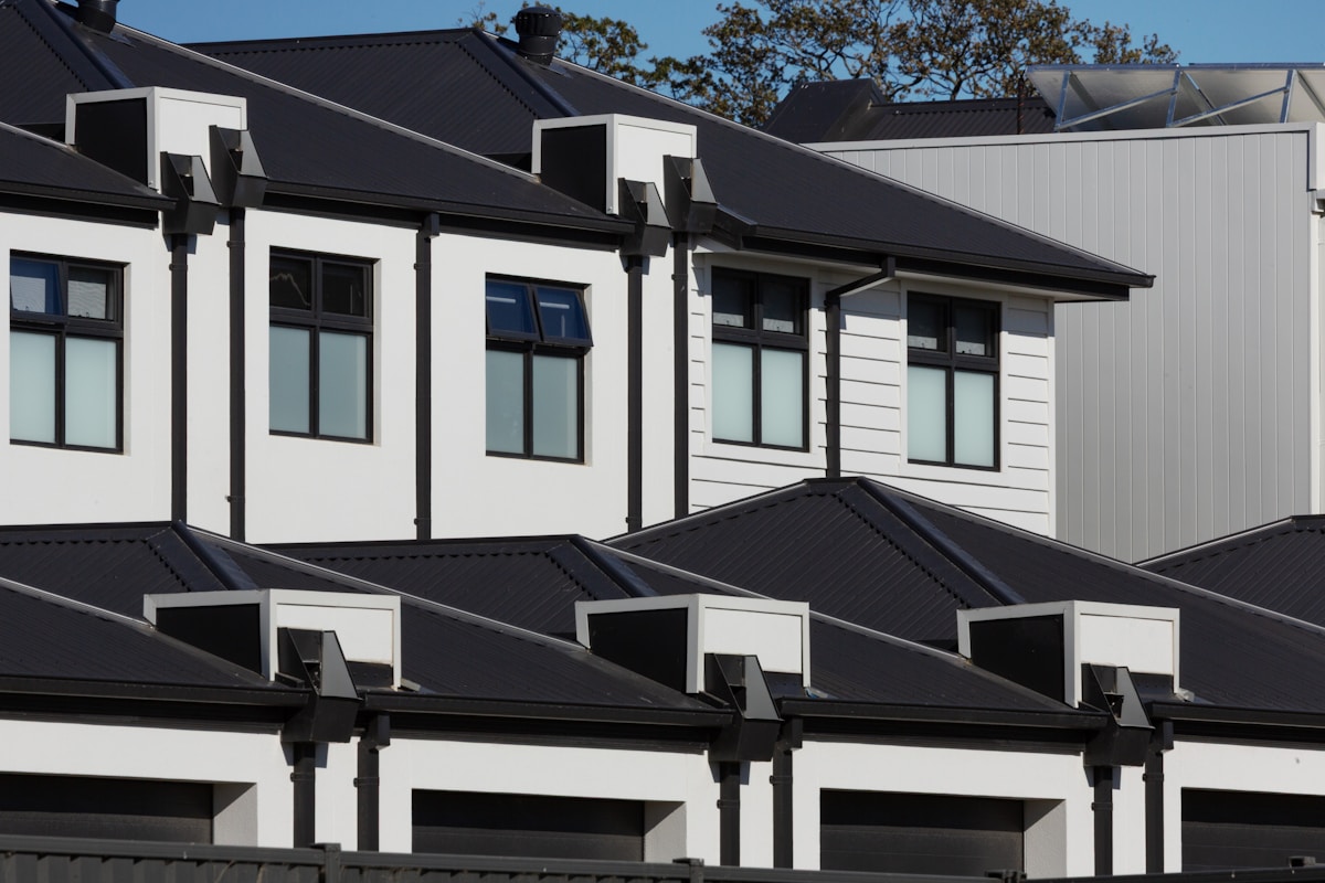 Row of modern white houses with black roofs