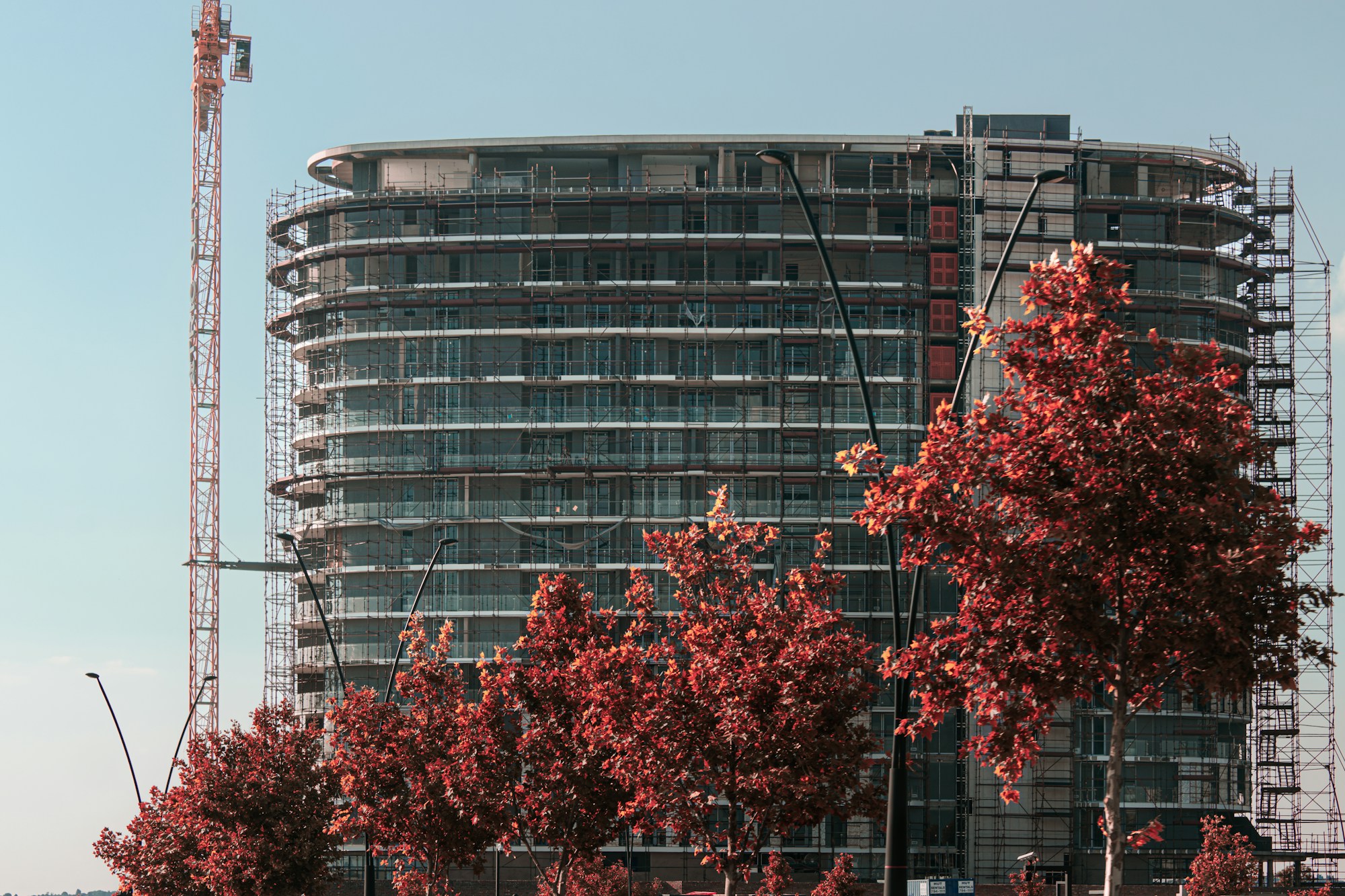 A tall building with a crane in the background